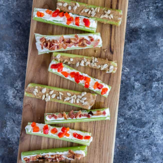 Stuffed celery three ways displayed on a wood cutting board