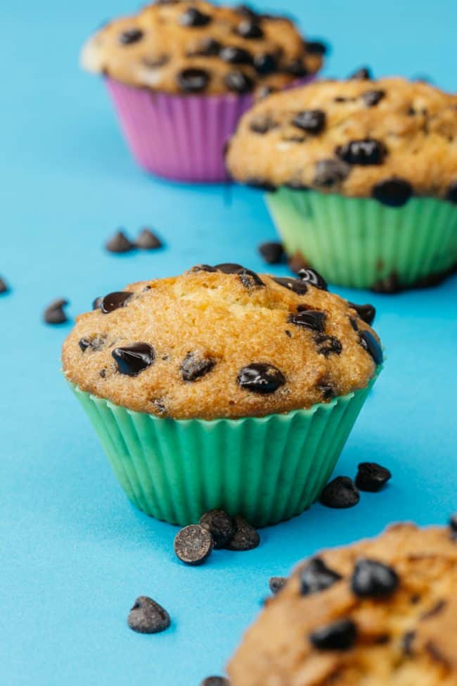 keto chocolate chip muffins on a blue table in muffin liners